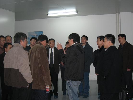 车间里，向电焊机协会参会代表讲解ag厅总部半导体整体运行情况